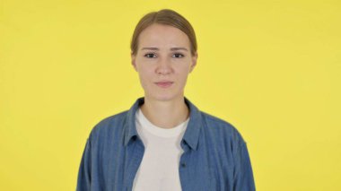 Ciddi Genç Kadın Sarı Arkaplanda Kameraya Bakıyor