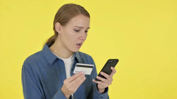 黄色の背景の女性によるスマートフォンのオンラインショッピングの失敗 — ストック写真