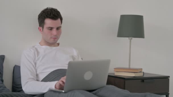 Férfi ünnepli siker Laptop az ágyban — Stock videók