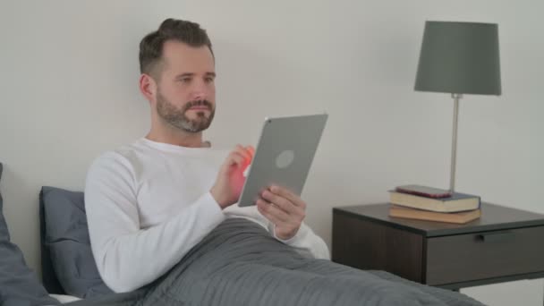 Homem usando Tablet na cama — Vídeo de Stock