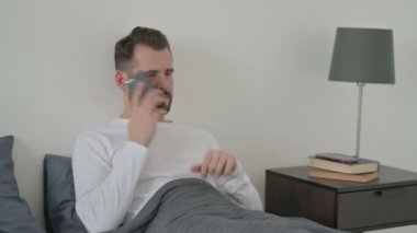 Yatakta Akıllı Telefonla Konuşan Kızgın Adam