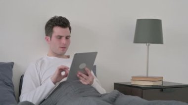 Adam yatakta otururken Tabletteki Kayba Tepki Veriyor