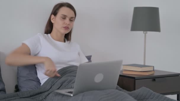 Donna con mal di schiena che lavora sul computer portatile a letto — Video Stock