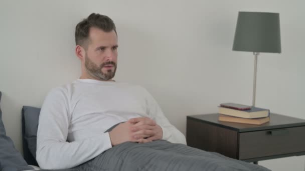 Mann hat Kopfschmerzen beim Schlafen im Bett — Stockvideo