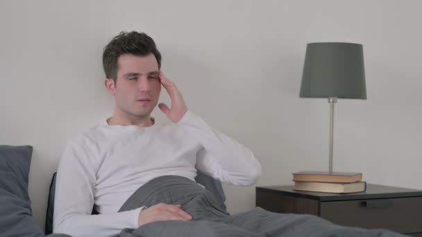 Ο άνθρωπος έχει πονοκέφαλο, ενώ κάθεται στο κρεβάτι — Αρχείο Βίντεο