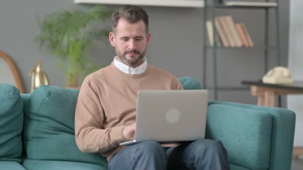 Mann schließt Laptop, verlässt Sofa — Stockvideo