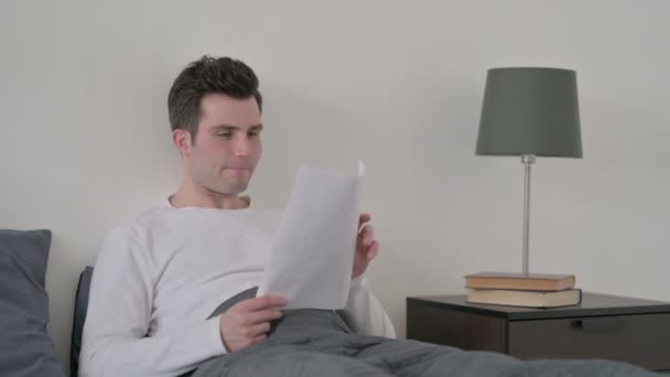 Людина втрачає документи в ліжку — стокове відео