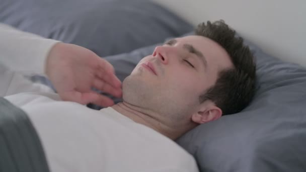 Férfi, akinek nyaki fájdalom, miközben alszik az ágyban, közelről — Stock videók