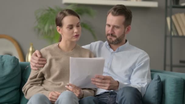 Documentos de leitura de casal juntos no sofá — Vídeo de Stock