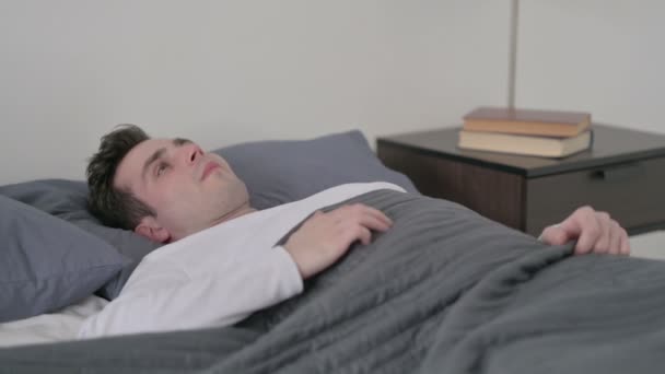 Człowiek leżący w łóżku niezdolny do snu — Wideo stockowe