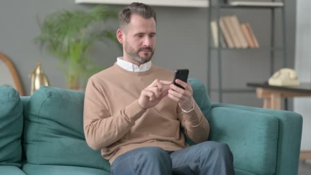 Homem tendo perda em Smartphone em casa — Vídeo de Stock