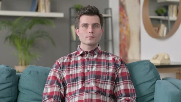 Портрет человека, оценивающего удачу во время сидения на Софе — стоковое видео
