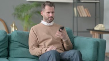 Kızgın Adam Akıllı Telefonla konuşuyor Kanepede 