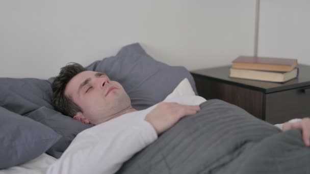 Человек просыпается от кошмара в постели — стоковое видео