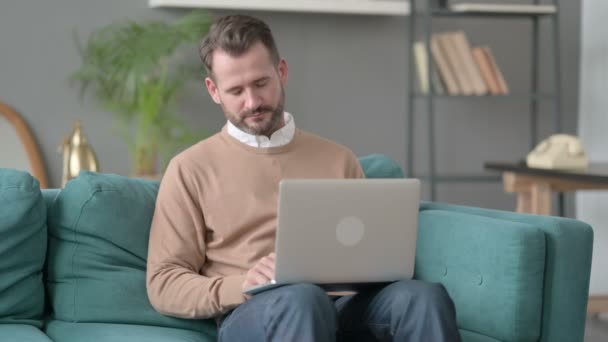 Uomo con computer portatile che prende pisolino sul divano — Video Stock