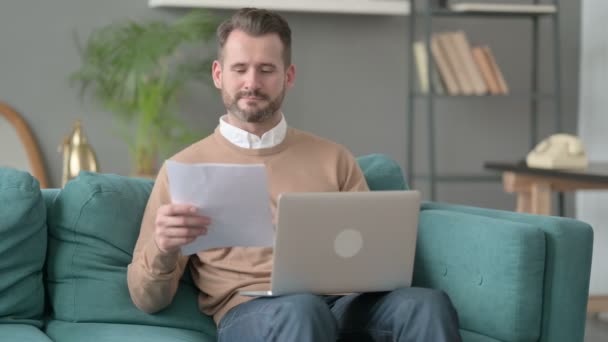 Hombre con ordenador portátil celebrando el éxito en el ordenador portátil, Sofá — Vídeos de Stock