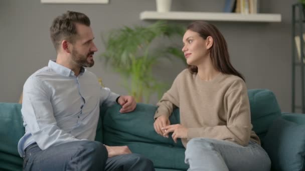 Пара серйозно розмовляє, сидячи на Софі — стокове відео