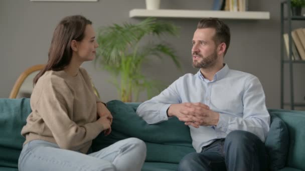 Happy Couple met conversatie tijdens het zitten op de bank — Stockvideo