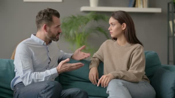 Uomo serio che parla con la donna mentre è seduto sul divano — Video Stock