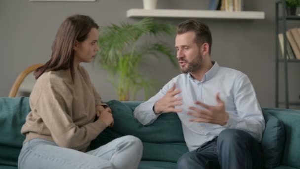 Homme sérieux parlant à une femme assis sur le canapé — Video