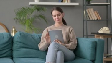 kanepede otururken tablet kullanan kadın 