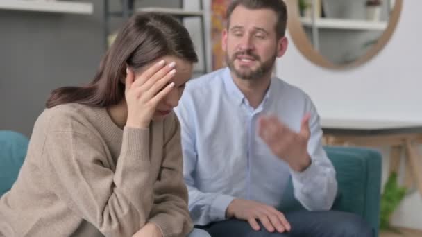Man grälar medan kvinnor känner sig stressade på soffan — Stockvideo