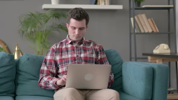 Uomo con computer portatile con mal di denti sul divano — Video Stock