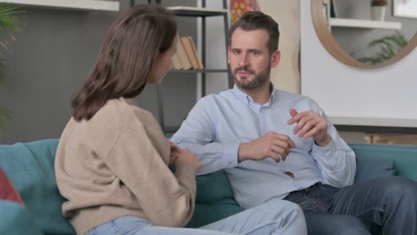 Homem sério conversando com mulher enquanto sentado no sofá — Vídeo de Stock