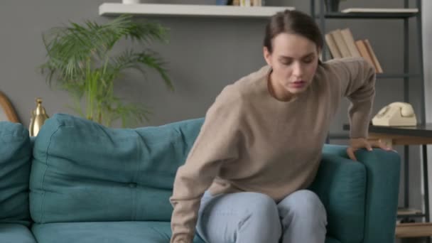 Kvinna som har ont i ryggen på soffan — Stockvideo