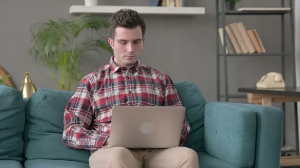 Muž dělá video hovor na notebooku na pohovce — Stock video