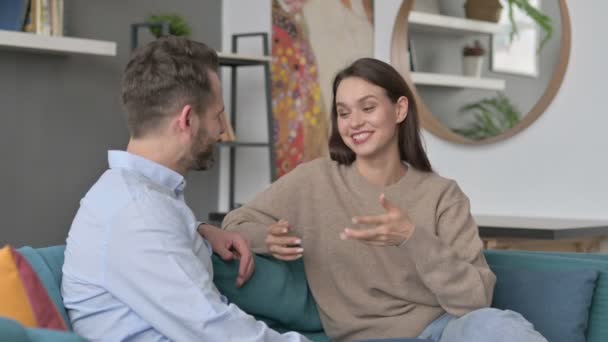 Glada par som har konversation medan du sitter på soffan — Stockvideo