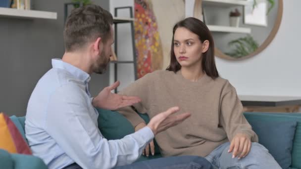 Allvarlig man pratar med kvinna medan du sitter på soffan — Stockvideo