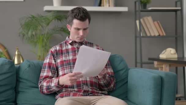 Hombre reaccionando a la pérdida de documentos, sofá — Vídeos de Stock