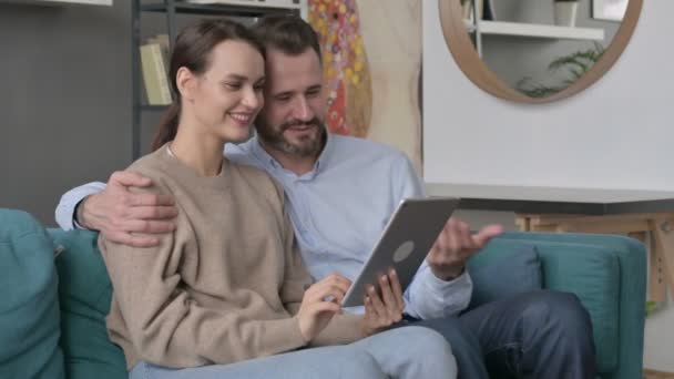 Couple faisant appel vidéo sur tablette tout en étant assis sur le canapé — Video