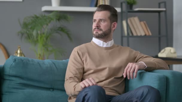 Hombre sentado en el sofá Pensando — Vídeos de Stock