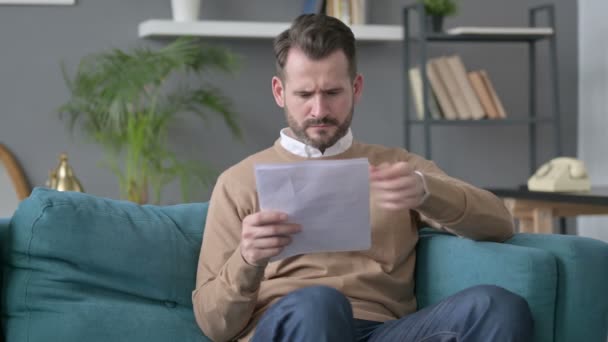 Hombre reaccionando a la pérdida de documentos, sofá — Vídeos de Stock