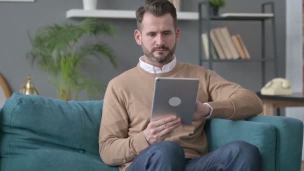 Hombre usando la tableta en el sofá — Vídeos de Stock