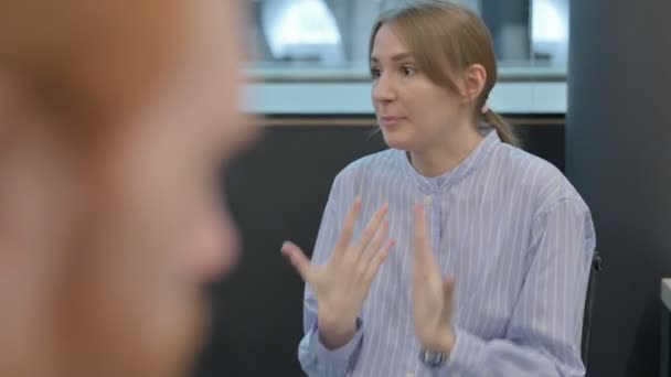 Zadní pohled vážné mladé ženy mluvící s osobou — Stock video