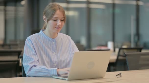 Młoda kobieta wyświetla kciuki w dół znak podczas korzystania z laptopa w biurze — Wideo stockowe