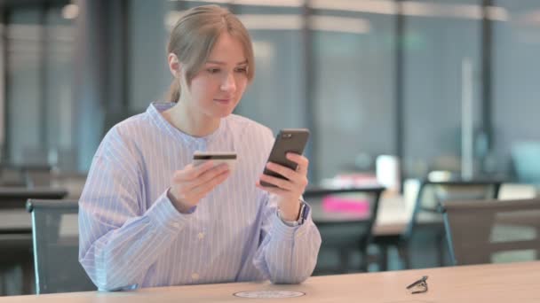 Mujer joven haciendo el pago en línea con éxito en el teléfono inteligente — Vídeos de Stock