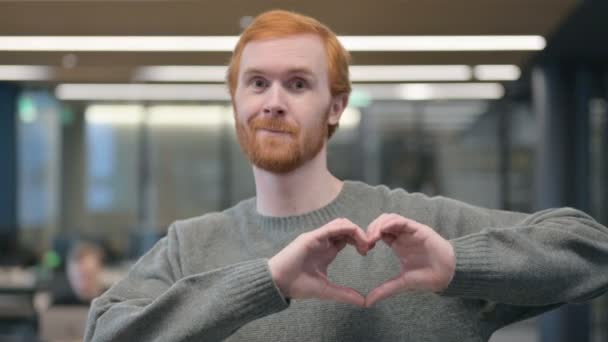 Portrait de jeune homme montrant la forme du cœur par les mains — Video