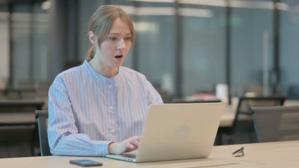 Giovane donna che reagisce alla perdita durante l'utilizzo del computer portatile — Video Stock