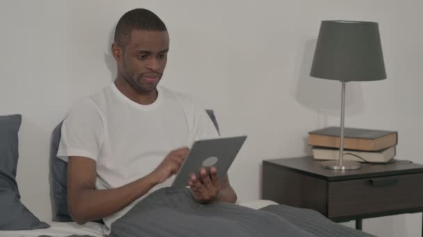 Mann benutzt Tablet im Bett — Stockvideo