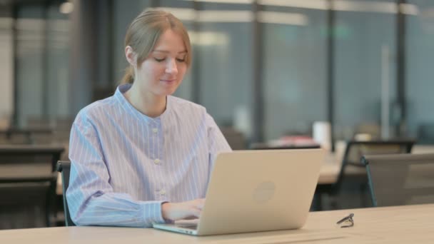 Молодая женщина чувствует шок во время использования ноутбука в офисе — стоковое видео