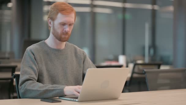Junger Mann hustet, während er Laptop im Büro benutzt — Stockvideo