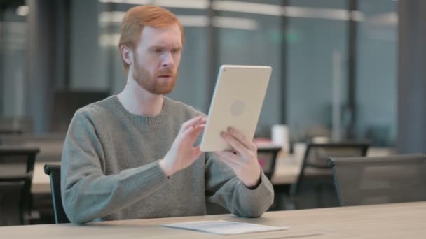 Jonge man reageert op verlies op tablet in kantoor — Stockvideo