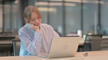 Ofiste dizüstü bilgisayarla otururken kestirirken yorgun genç kadın