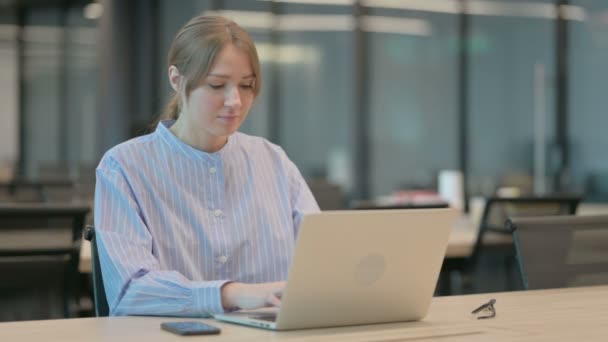 Fiatal nő vigyorog a kamera használata közben Laptop az irodában — Stock videók