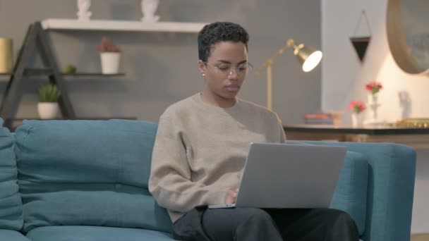 Afrikansk kvinna som arbetar på laptop på soffan — Stockvideo