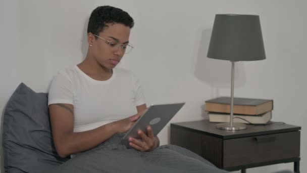 ベッドに座りながらタブレットを使うアフリカ人女性 — ストック動画